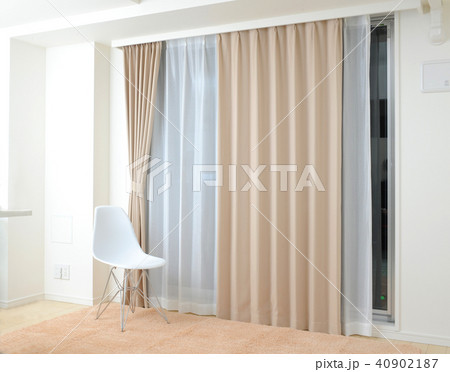 インテリア　ベージュ色のカーテンと白い椅子 40902187