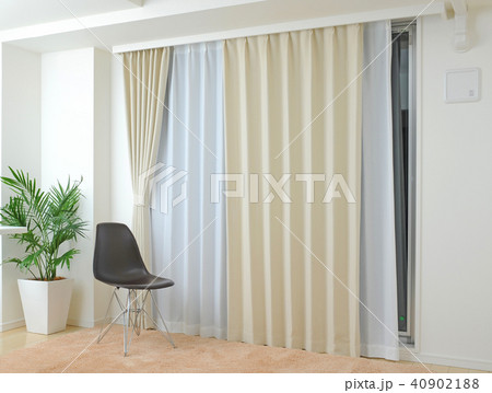 インテリア　ベージュ色のカーテンと黒い椅子 40902188