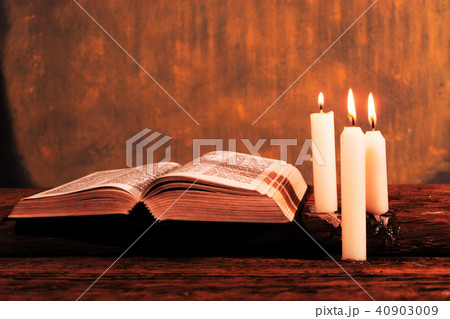 Bible and candle on a old oak wooden table. 40903009