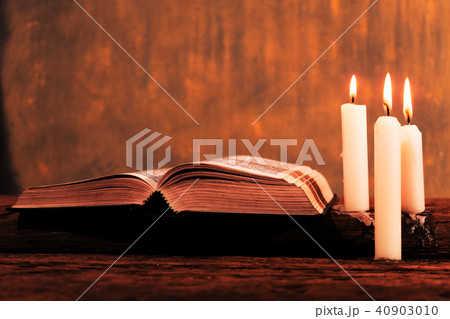 Bible and candle on a old oak wooden table. Bible and candle on a old oak wooden table. 40903010