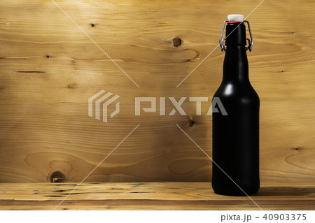 bottle of beer with a crust on a wooden oak table. bottle of beer with a crust on a wooden oak table. 40903375