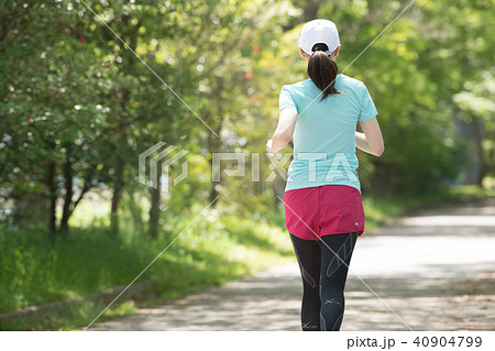 走る若い日本人女性の後ろ姿の写真素材