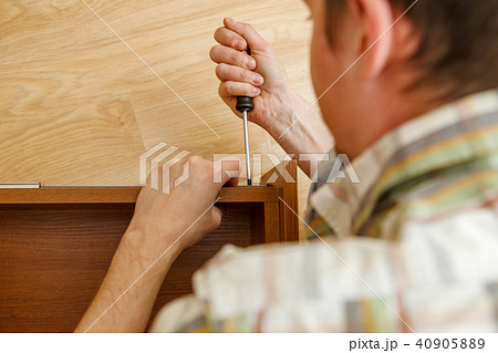 Photo of man with screwdriver picking box Photo of man with screwdriver picking box 40905889