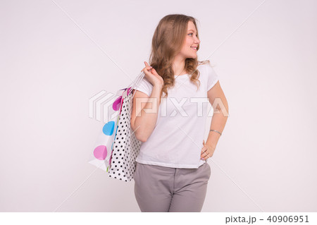 Portrait of young happy smiling woman with shopping bags on white background 40906951