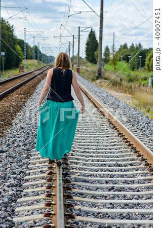 Young women walking on the rail track 40907451
