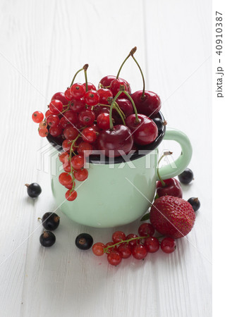 Different kinds of berries in enamel tea cup 40910387