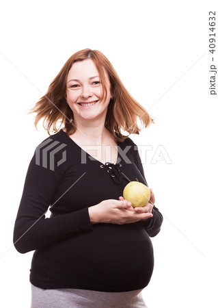 Beautiful pregnant happy woman holds an apple in her hands Beautiful pregnant happy woman holds an apple in her hands 40914632