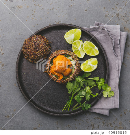 Fresh opened sea urchins. Caviar of sea urchins with onion, cilantro and lemon inside of shell of Fresh opened sea urchins. Caviar of sea urchins with onion, cilantro and lemon inside of shell of 40916016