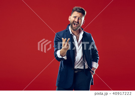 Beautiful male half-length portrait isolated on red studio backgroud. The young emotional surprised 40917222