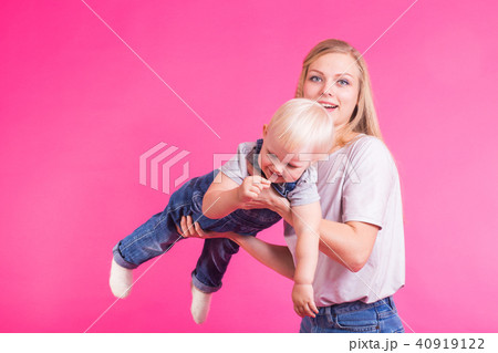 young mother and daughter having fun together on pink background 40919122