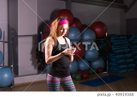 Attractive woman using cell phone in gym Attractive woman using cell phone in gym 40919388