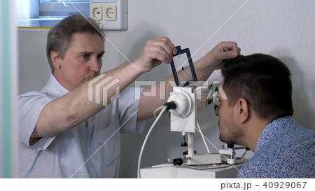Senior optometrist doing sight testing for patient 40929067