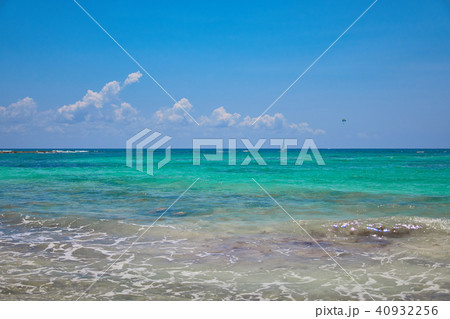 View of tropical beach. Tourists ride parasailing boat with parachute. Sailing yacht sails on waves 40932256