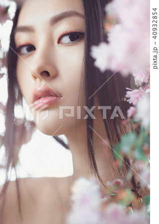 Portrait of a beautiful fantasy asian girl outdoors against natural spring flower background. 40932854