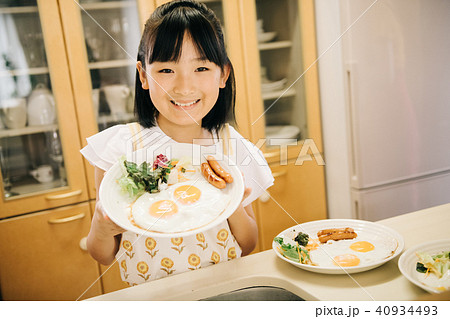 料理をお手伝いする小学生の女の子の写真素材