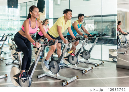 Fit women burning calories during indoor cycling class in a fitness club 40935742
