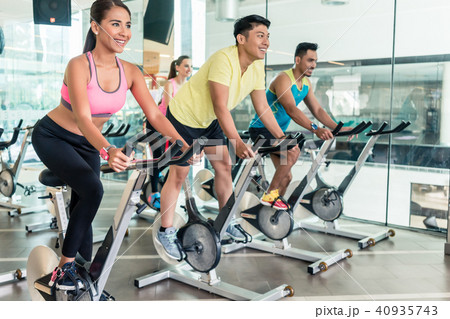 Fit women burning calories during indoor cycling class in a fitness club 40935743