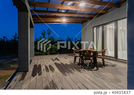 Side view of an open veranda in front of a modern forest cottage. Pine young forest under the sunset 40935837