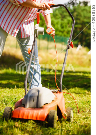Woman being mowing lawn with lawnmower Woman being mowing lawn with lawnmower 40938565