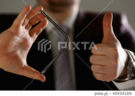 Man in suit and tie bend nail with arms closeup 40939169