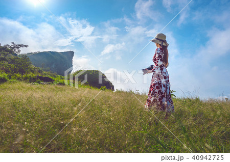Woman standing on meadow and holding camera  40942725