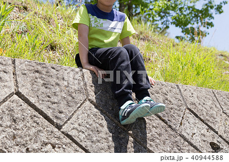 塀に座る子供の写真素材