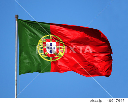 National flag of Portugal on a flagpole in front of blue sky National flag of Portugal on a flagpole in front of blue sky 40947945