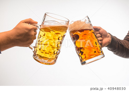 hands with mugs of beer toasting creating splash isolated on white background 40948030