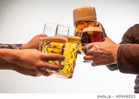 hands with mugs of beer toasting creating splash isolated on white background 40948033