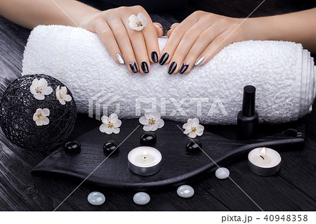beautiful black manicure with apricot flower and towel on the wooden table. spa 40948358
