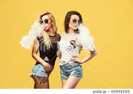 Stylish young woman in sunglasses smoking Stylish young woman in sunglasses smoking 40948366