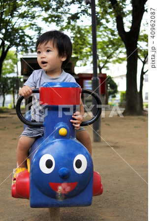 公園の遊具で遊ぶ1歳男児の写真素材