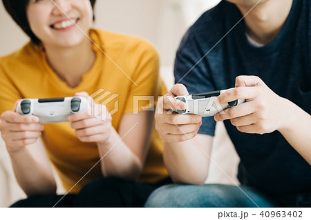 テレビゲームで遊ぶ若い日本人夫婦の写真素材