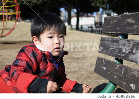 公園の遊具で遊ぶ2歳男児の写真素材
