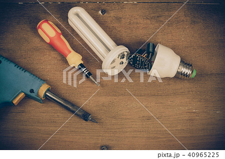 repair Energy saving light bulbs on wood table. repair Energy saving light bulbs on wood table. 40965225