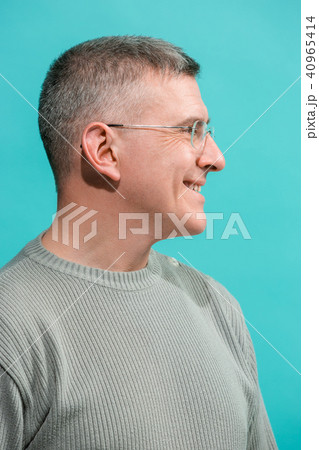 The happy business man standing and smiling against blue background. The happy business man standing and smiling against blue background. 40965414