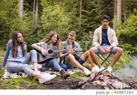 Teenagers wit a guitar camping in forest. 40967265