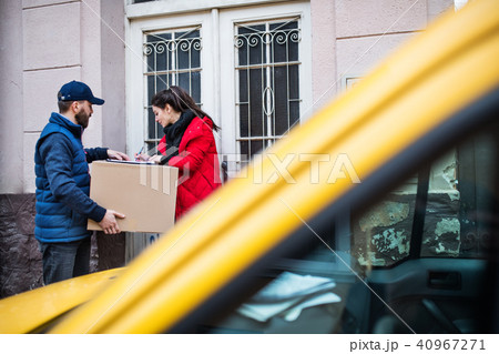 Woman receiving parcel from delivery man at the door. Woman receiving parcel from delivery man at the door. 40967271