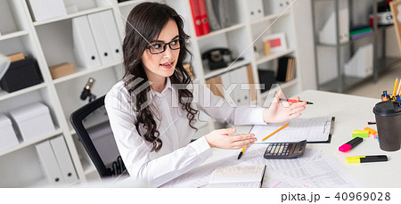 Beautiful young girl is sitting at the table in the office and is holding negotiations. 40969028