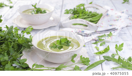 Cream soup of green peas and Parsley. Healthy lunch in a white plate on a white wooden background, Cream soup of green peas and Parsley. Healthy lunch in a white plate on a white wooden background, 40975055