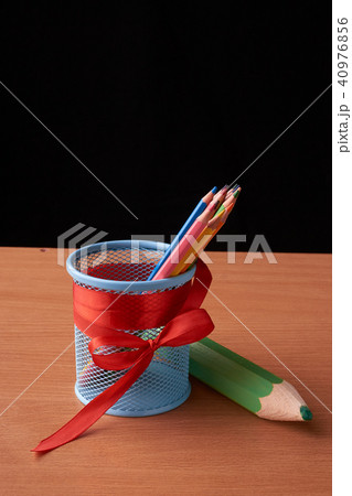 color pencils in tin can on wood table on black  40976856