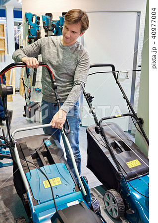 Man chooses lawn mower in store Man chooses lawn mower in store 40977004