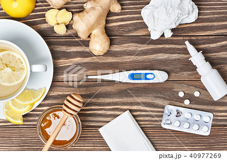 Cup ginger tea, honey, lemon, pills, thermometer 40977269