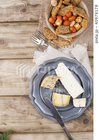 Snack on the plate and different cheese for the party. Vintage photo. Wooden background. Copy space. Snack on the plate and different cheese for the party. Vintage photo. Wooden background. Copy space. 40979178