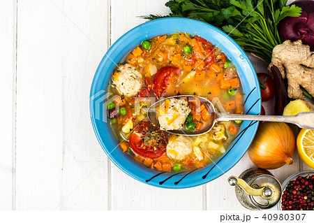 Chicken broth with vegetables and meatballs 40980307