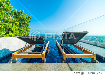 Chair and bed around swimming pool in hotel 40981747