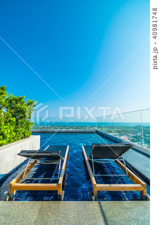 Chair and bed around swimming pool in hotel 40981748