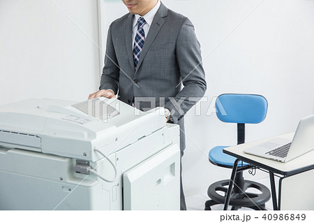 コピー機の前で仕事をするスーツの男性 40986849