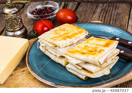 Envelopes of thin Armenian bread lavash fried with crispy crust. Filling of cheese, tomato and Envelopes of thin Armenian bread lavash fried with crispy crust. Filling of cheese, tomato and 40987037