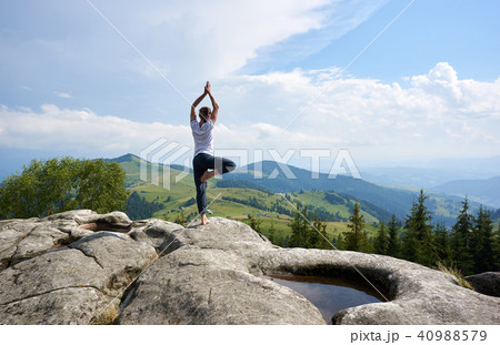 Young woman resting on a big stone in the summer day in the Carpathian mountains Young woman resting on a big stone in the summer day in the Carpathian mountains 40988579